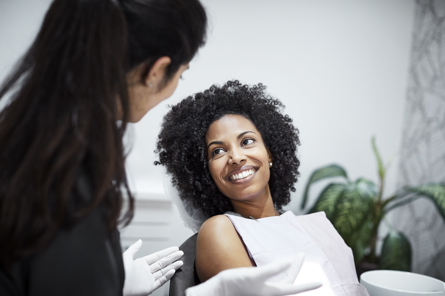 Photograph of a young Black female patient in a dental chair for a regular dental checkup.