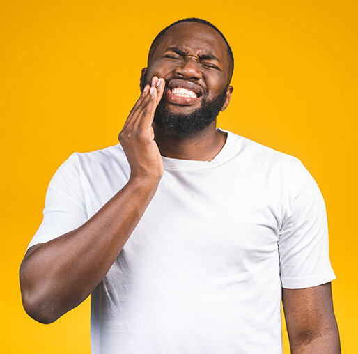 man holding his jaw in pain