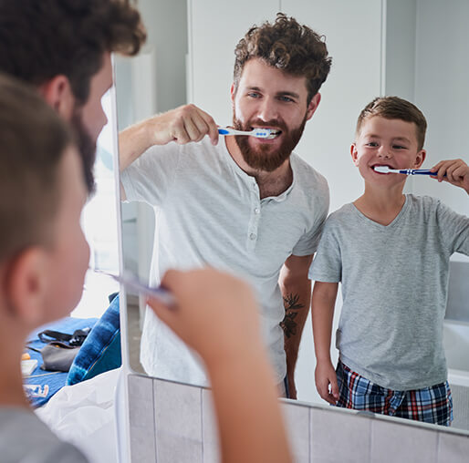 father and son brushing their teeth together