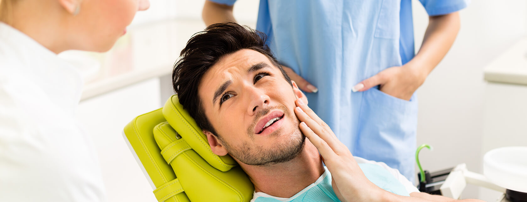 man holding his jaw in pain